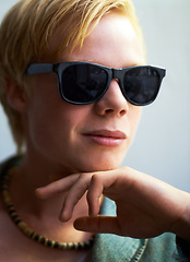 Image showing Portrait, sunglasses and a cool young boy in studio on a gray background for trendy youth fashion. Face, kids and attitude with a confident child in shades to model an outfit as a teenage model