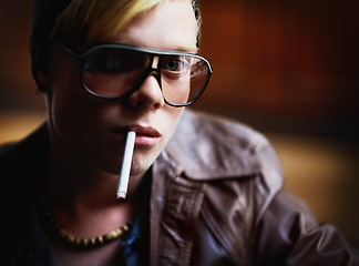 Image showing Portrait, addiction and a boy smoking a cigarette closeup for nicotine or tobacco dependency in sunglasses. Face, smoke and bad habit with a young person inhaling an addictive substance for cancer