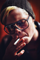 Image showing Face, addiction and a boy smoking a cigarette closeup for nicotine or tobacco dependency in sunglasses. Style, smoke and bad habit with a young person inhaling an addictive substance for cancer