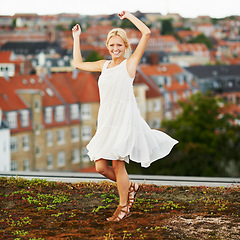 Image showing Portrait, dance and smile with a woman on a roof in her neighborhood for energy or freedom in summer. Music, movement and a happy young person in celebration of her holiday or vacation as a tourist