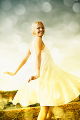 Image showing Smile, bokeh and blonde woman in dress in the countryside, dance and freedom outdoor in summer. Happy, nature and person moving with energy on holiday, vacation or celebration for travel on field