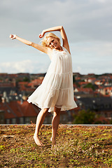 Image showing Woman, freedom and dancing on vacation, happiness and outdoor for holiday, smiling and city. Summer, dancer and urban area for break, getaway and carefree on trip, barefoot and amsterdam spring time