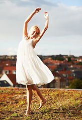 Image showing Woman, joyful and dancer on vacation, summer and outdoor for holiday, smiling and dress. Rooftop, dancing and urban area for break, getaway and carefree on skyline, barefoot and amsterdam spring time