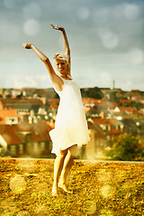 Image showing Dancing, portrait and freedom of woman outdoor on holiday, vacation or travel in city. Happy blonde person with arms raised in celebration, smile and moving with energy in Amsterdam in summer bokeh