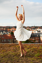 Image showing Woman, spinning and dancing on carefree, holiday and outdoor for vacation, smiling and city. Wind, dancer and urban area for break, getaway and carefree on trip, barefoot and amsterdam spring time