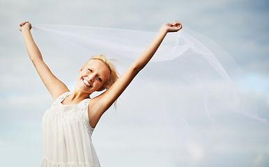 Image showing Portrait, happy and woman with chiffon in wind outdoor for summer, vacation or travel on holiday. Face, smile and dress or fabric fly for freedom, beauty and elegant, fashion or glamour on blue sky