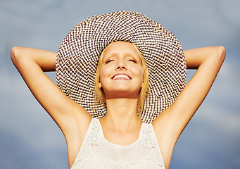 Image showing Woman, sun hat or summer blue sky for vacation holiday bliss, tropical island or smile travel. Female person, beach cap or arms up for outdoor happy or relax rest trip, satisfaction or warm weather