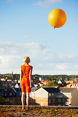 Image showing Woman, back and balloon for birthday, sky and city for holiday, freedom and stylish dress. Rooftop, skyline and vacation with buildings, celebration and break for special day, alone and Amsterdam