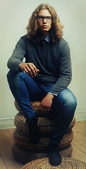 Image showing Man, portrait and fashion or style trendy clothes, wall background or long hair. Male person, model and face glasses for denim outfit or indoor confidence for edgy unique, serious cool or fresh look