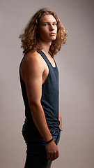 Image showing Man, model and fashion in portrait in a studio with casual clothes, curly hairstyle and cool style. Summer outfit, trendy and stylish with serious face, young with hair and gen z on grey background