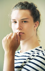 Image showing Portrait, man and thinking in studio for fashion, clothes or style in London. Young person, male model and serious look on face, hand and mouth for hairstyle, cool or trendy on background in space