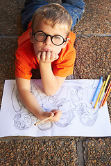 Image showing Portrait, creative and student with a sketch, drawing and creativity with a talent, learning and paper on the ground. Face, kid and child with knowledge, development or artistic with colour or pencil