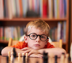 Image showing Portrait, chess and boy with glasses, bored and competition with training, skills and clear vision. Face, person or kid with eyewear, tournament or game with thinking, contemplation, ADHD or solution