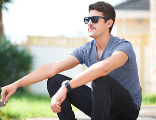 Image showing Man in sunglasses, sitting with cigarette or thinking, relax outdoor and fashion at backyard of home or house. Smoking, cool person in glasses or style, trendy and hipster in casual clothes or tshirt