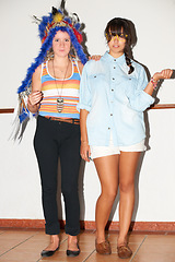 Image showing Fashion portrait, friends and women in home in cool hipster clothes for dress up. Serious girls, style and trendy in house, bonding or standing together with glasses, Native American headdress or hat