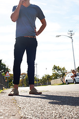 Image showing Standing, legs and a man with a shadow in the street for walking, enjoying summer or a break. Low, fashion and a person in the road for relax, sunshine or urban in a neighborhood for stylish