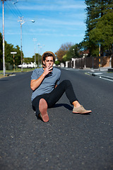 Image showing Cool, man and sitting in the street for smoking, stylish and streetwear fashion. Trendy, young and a person with a cigarette for smoke, tobacco or nicotine habit in the road for youth aesthetic