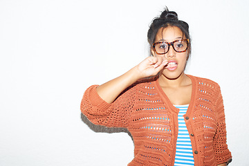 Image showing Studio background, portrait and a flirty woman biting finger for fashion, streetwear or urban culture. Model, glasses and a young girl or person with mockup, flirting or stylish on a backdrop