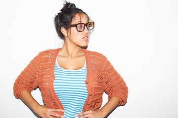 Image showing Fashion, glasses and woman in studio with clothes, style and attitude against a wall background. Fashionable, stylish and female model person posting with confidence, cool or trendy, casual or outfit