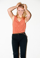 Image showing Fashion, frustrated and portrait of woman with attitude, anger and style on a white background. Attractive, pulling hair and isolated person in trendy clothes, casual outfit and stylish in studio