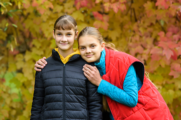 Image showing Portrait of two girls of Slavic appearance in casual autumn clothes against the background of an autumn forest