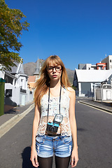 Image showing City, photographer and portrait of serious woman with camera for creative and art career traveling. Gen z, paparazzi and young female person from Australia with dslr equipment for vacation in town.