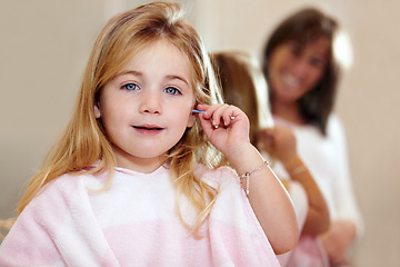 Image showing Portrait, hygiene and a child cleaning ears with an earbud in a home bathroom for grooming. Smile, cotton and a girl or young kid learning to clean body during morning routine and getting ready