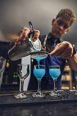 Image showing Bartender pouring fresh blue cocktail