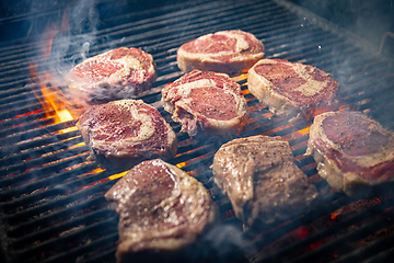 Image showing Steaks are in various stages of cooking