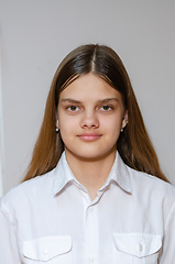 Image showing Portrait of a fourteen-year-old girl in a white shirt on a gray background