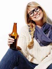 Image showing Happy woman, portrait smile and relax with beer of nerd, geek or hipster against a studio background. Attractive female person or model with glasses, nerdy or fashion style holding bottle of alcohol