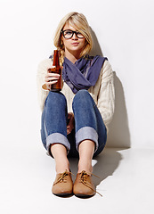 Image showing Portrait, beer and a bottle with a woman drinking in studio on a mockup white background. Party, event or alcohol with a young drunk girl enjoying a glass beverage for celebration or to relax