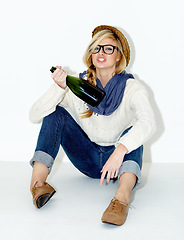 Image showing Champagne, drunk or woman on floor with hangover from hipster, rebel or event in studio. Relax, festive or female person drinking alcohol or beverage in bottle for New Year on white background