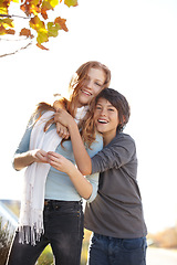 Image showing Woman, autumn hug and friends portrait at park with smile and happy from travel, vacation and leaves. Holiday, outdoor and calm female person in New York with freedom and adventure by tree in garden