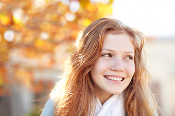 Image showing Woman, autumn and nature at park with smile and happy from travel, vacation and colorful leaves. Holiday, outdoor and calm female person in New York with freedom and adventure by a tree in a garden