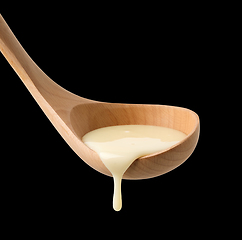 Image showing condensed milk in wooden ladle