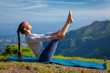 Image showing Woman doing Ashtanga Vinyasa Yoga asana Navasana - boat pose