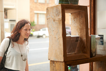 Image showing Book store, window shopping and sale with woman with discount and customer with choice. City, town and sidewalk with a female person at shop and boutique for purchase, library and glass on urban road