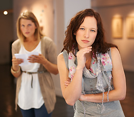 Image showing Looking, portrait and women at a gallery for art, creativity and paintings on display on the weekend. Thinking, young and friends or people at a museum for education and learning about culture