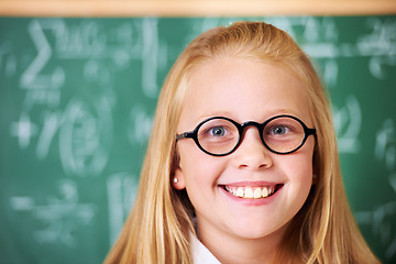 Image showing Portrait of student, nerd and happy child by chalkboard in class for learning knowledge, education and study math. Face, glasses and smile of geek at school, girl or cute kid in classroom in Canada