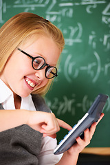 Image showing child, girl and calculator by chalkboard for happy education, learning and problem solving or solution. Smart student or child with glasses and excited for school, typing numbers or math in classroom