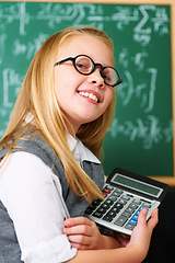 Image showing Smile, calculator and child student in classroom for mathematics homework, lesson or test. Learning, education and portrait of happy young girl kid with glasses and maths equipment by board in school