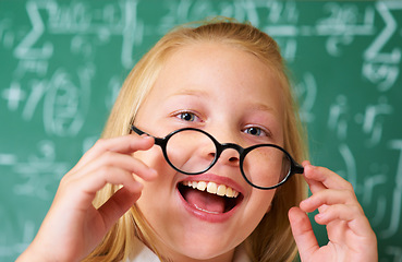 Image showing Excited, smile and portrait of child student in classroom with glasses by board for lesson or studying. Education, learning and happy young girl kid with positive attitude for scholarship in school.