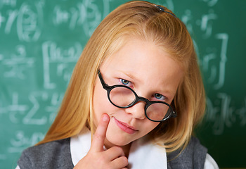 Image showing Portrait of student, nerd and kid thinking by chalkboard in class for learning knowledge, education and study math. Face, glasses and geek at school, blonde girl and child in classroom in Switzerland