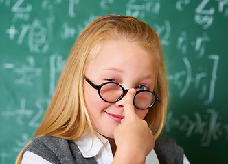 Image showing Portrait of nerd, glasses and happy kid by chalkboard in class for learning knowledge, education and study math. Face, student and smile of geek at school, girl or cute child in classroom in Canada