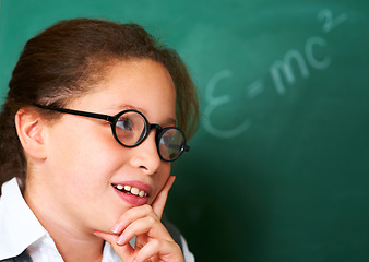 Image showing Thinking, idea and child student in classroom with idea, solution or brainstorming facial expression. Smile, education and young girl kid with glasses for learning or planning with board in school.