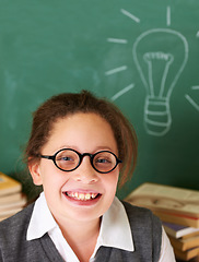 Image showing Happy, smile and portrait of student with light bulb on board for plan, decision or brainstorming in classroom. Education, learning and girl child with drawing for choice, vision or future in school.