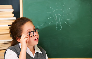 Image showing Thinking, idea and student with light bulb on board for planning, decision or brainstorming in classroom. Education, learning and girl child with drawing for choice, vision or future in school.