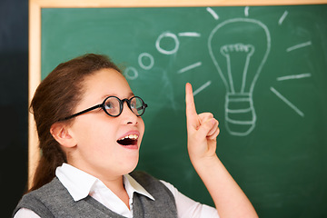 Image showing Girl, thinking and light bulb on chalkboard for solution, ideas and wow with education, learning and classroom knowledge. Child, student or school kid with vision, inspiration and lightbulb doodle