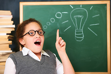 Image showing Girl, thinking and lightbulb on chalkboard for solution, ideas and wow in education, learning and classroom knowledge. Child, student or school kid with vision, inspiration and light bulb doodle